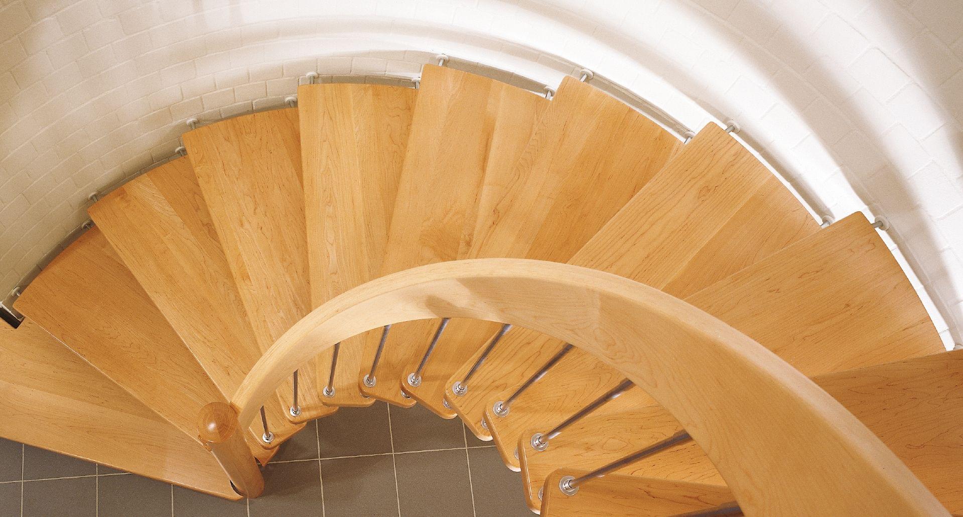 Holztreppe Bogentreppe mit Edelstahl Stäben und Holzhandlauf.